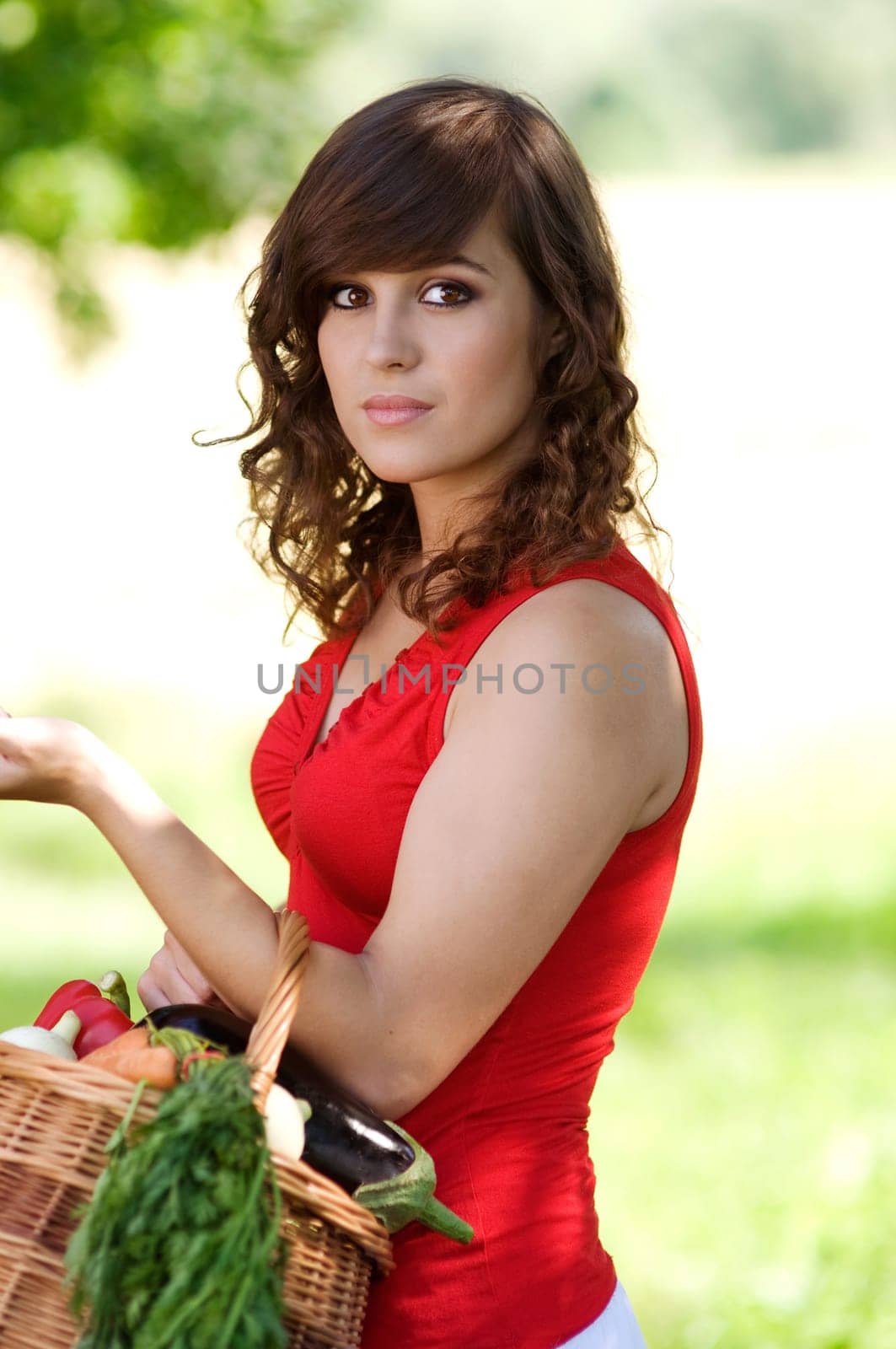 Young woman with basket filled fresh vegetables