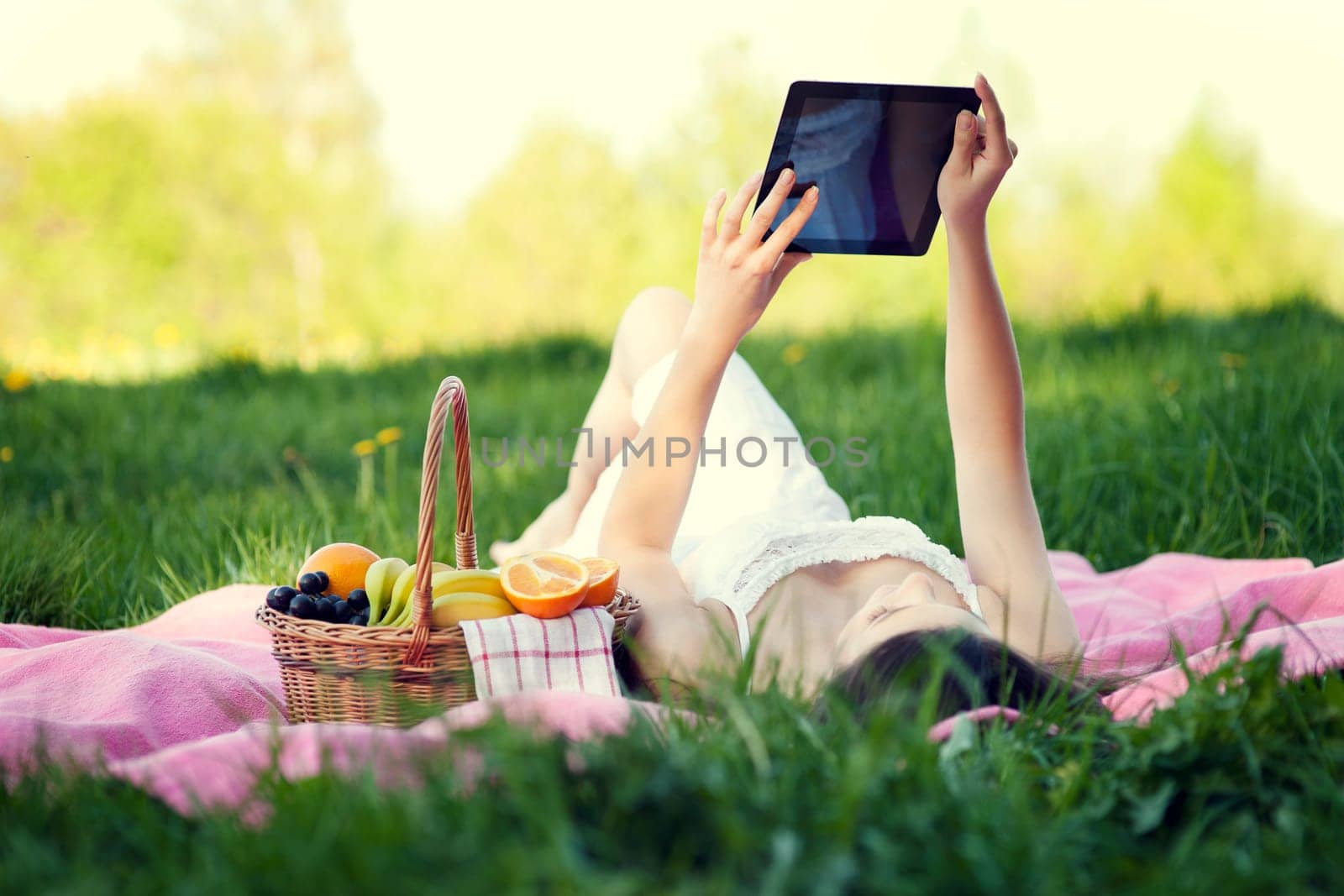 Young woman using digital tablet on meadow