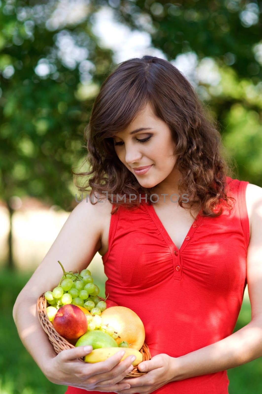 Young woman holding basket filled mix fruit