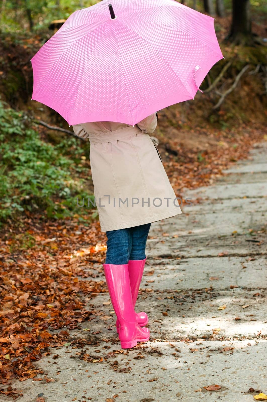 Young woman with umbrella walking through the park