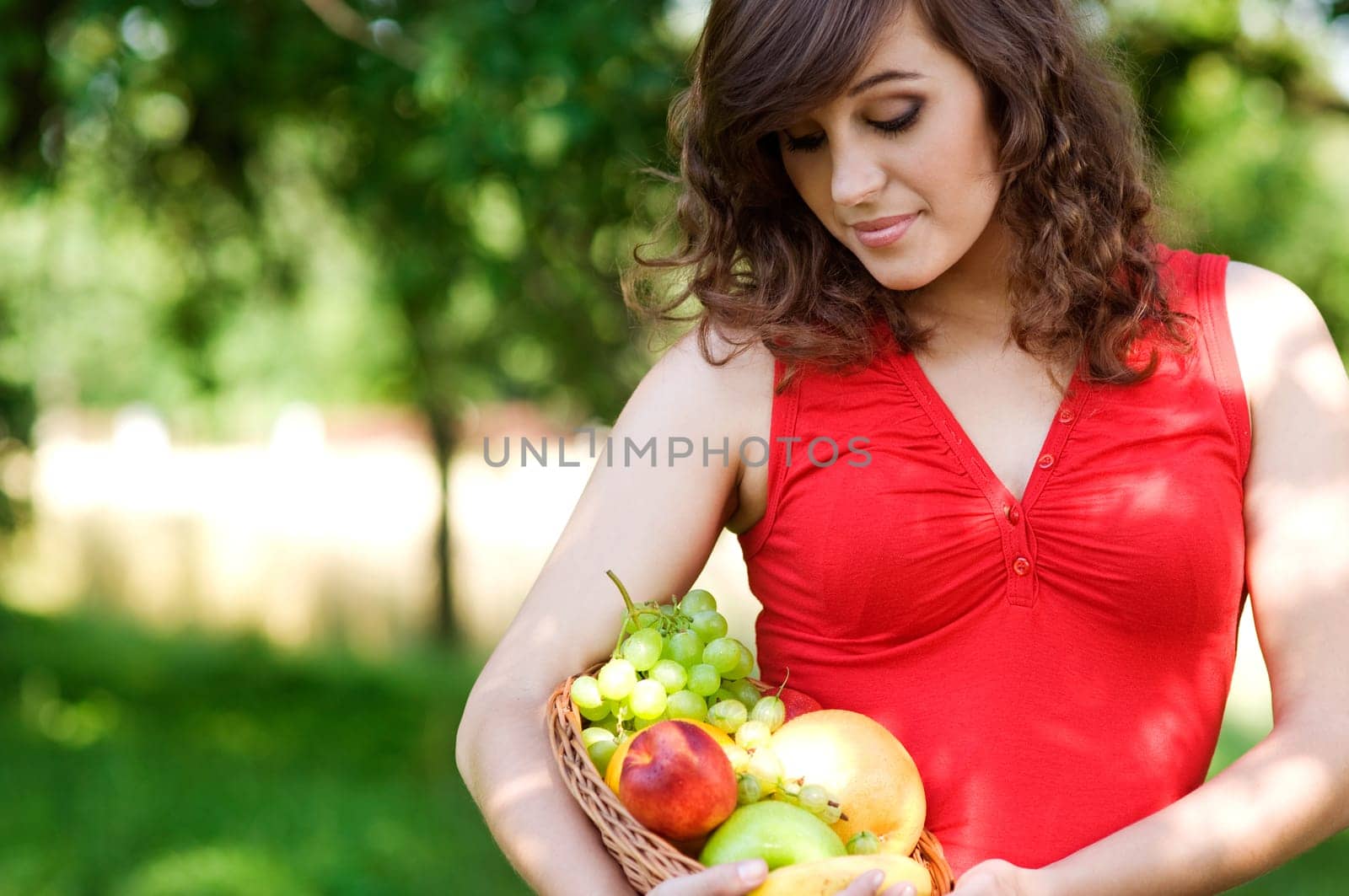 Young woman holding basket filled mix fruit