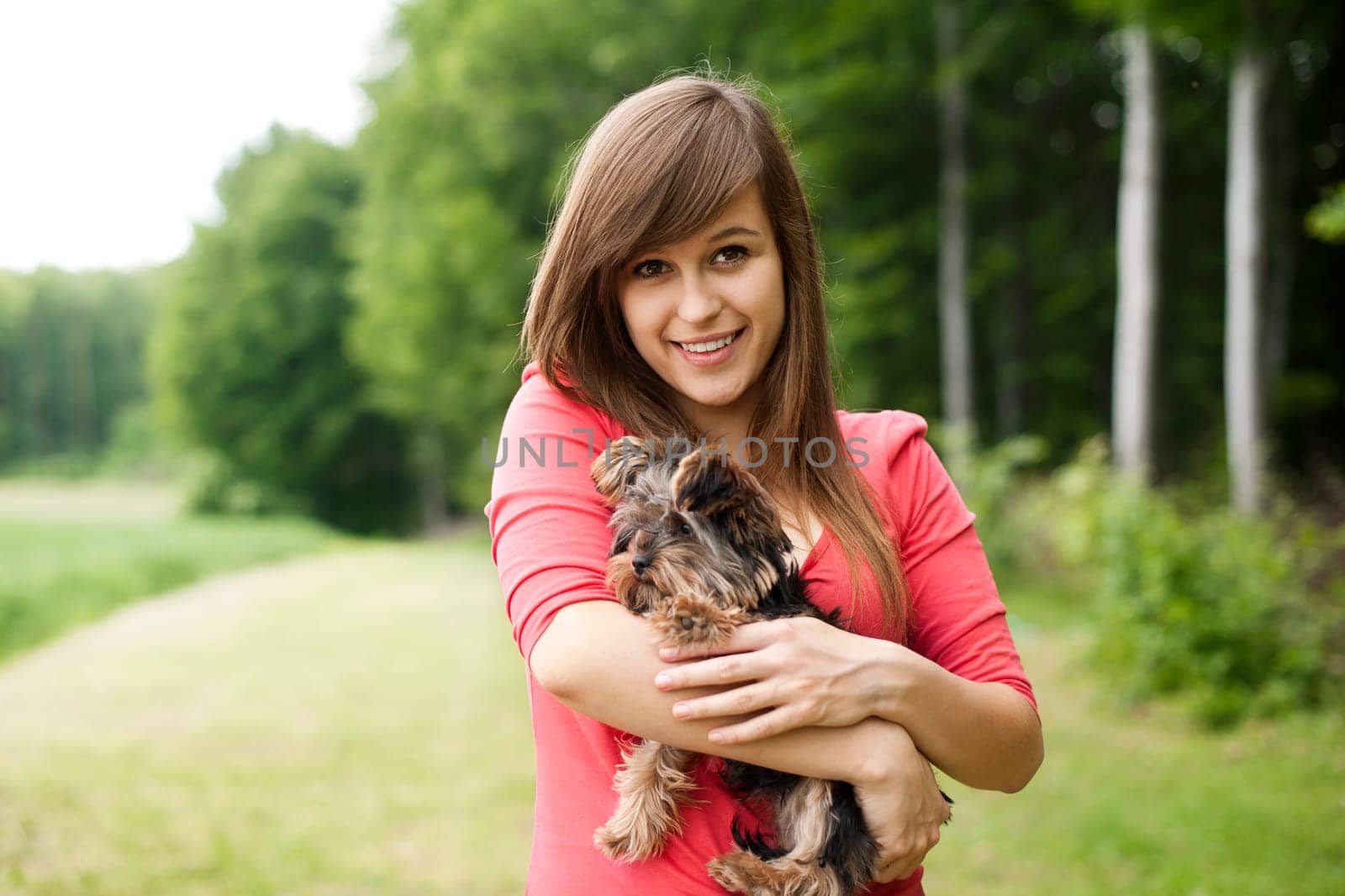 Smiling woman holding cute puppy