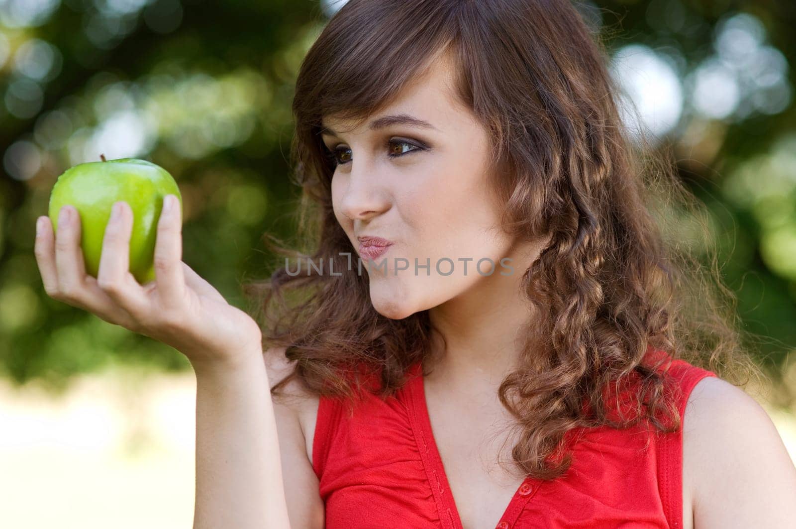 Young woman wondering about eating apple