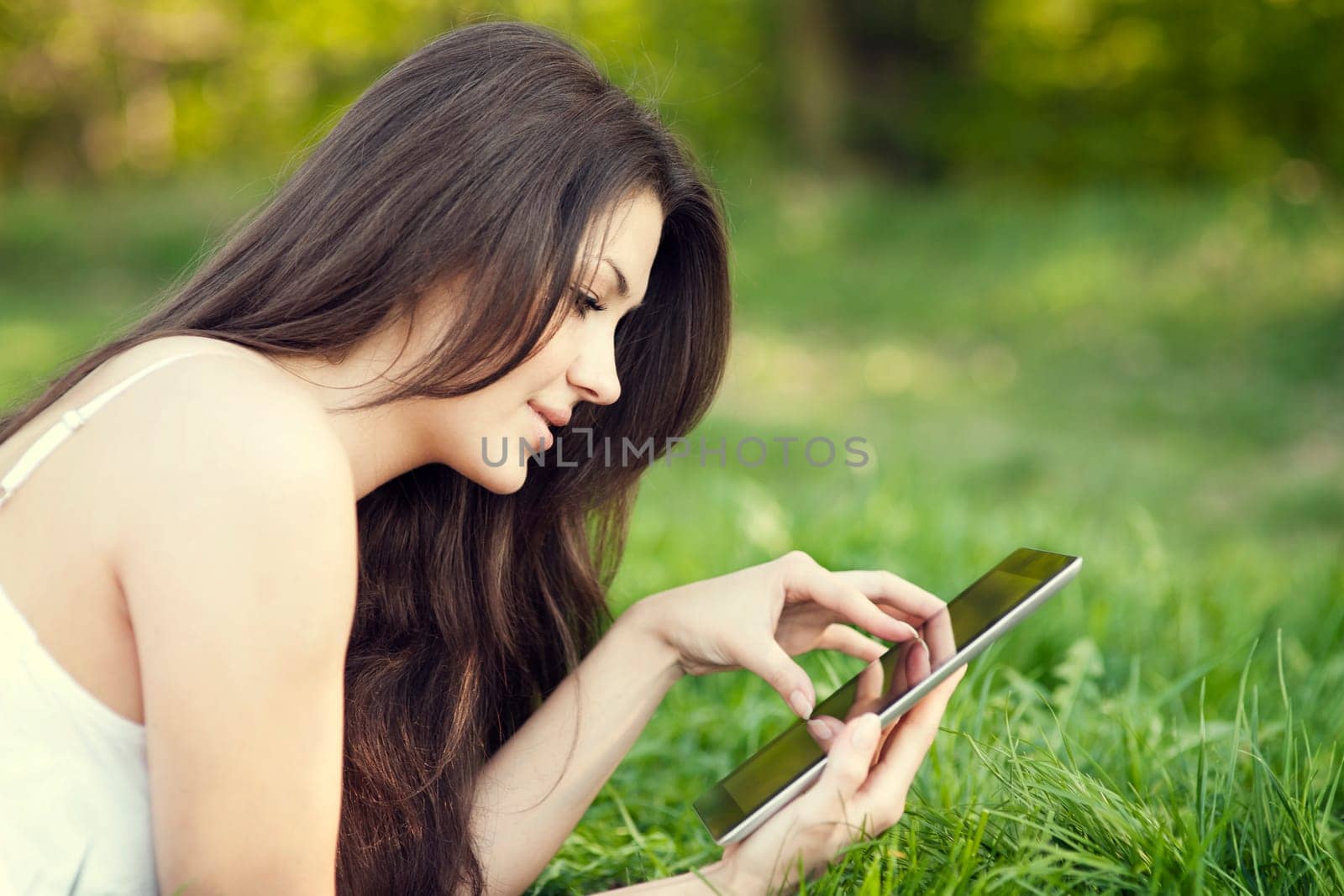 Young woman using digital tablet on meadow