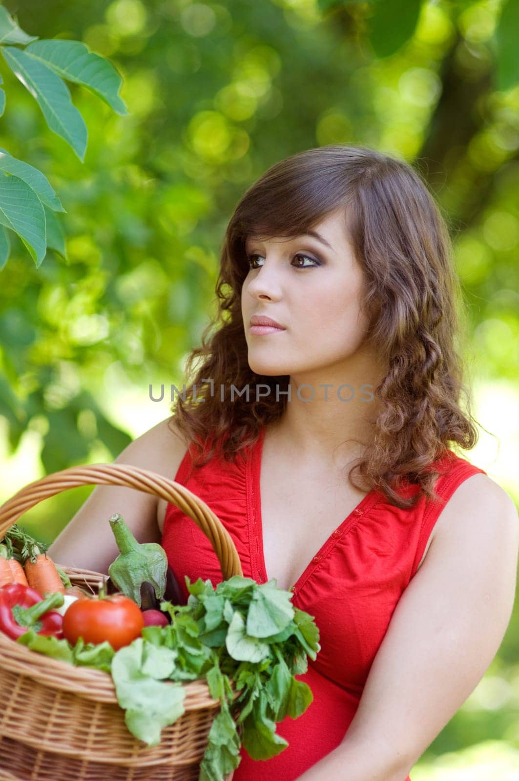 Young woman holding basket filled vegetables