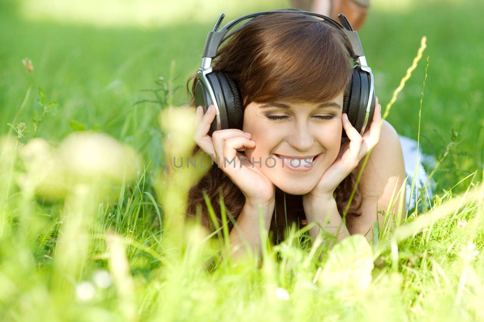 Young woman listening music on grass