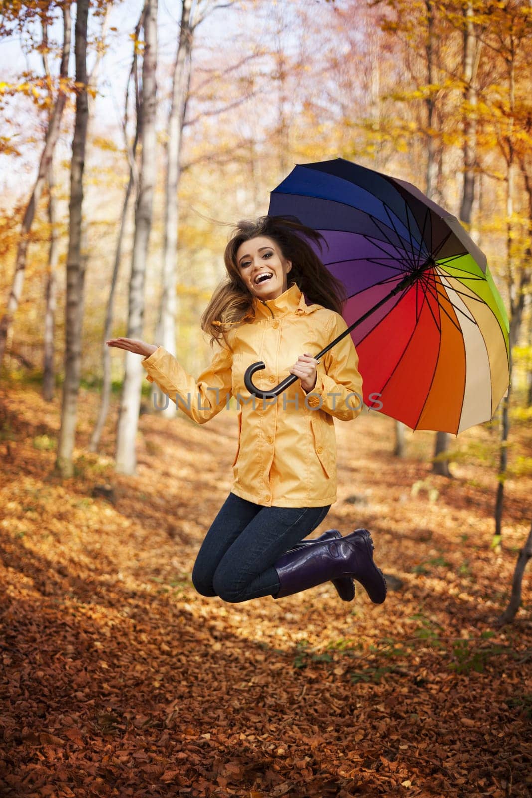 Young woman jumping during the rainy day at autumn