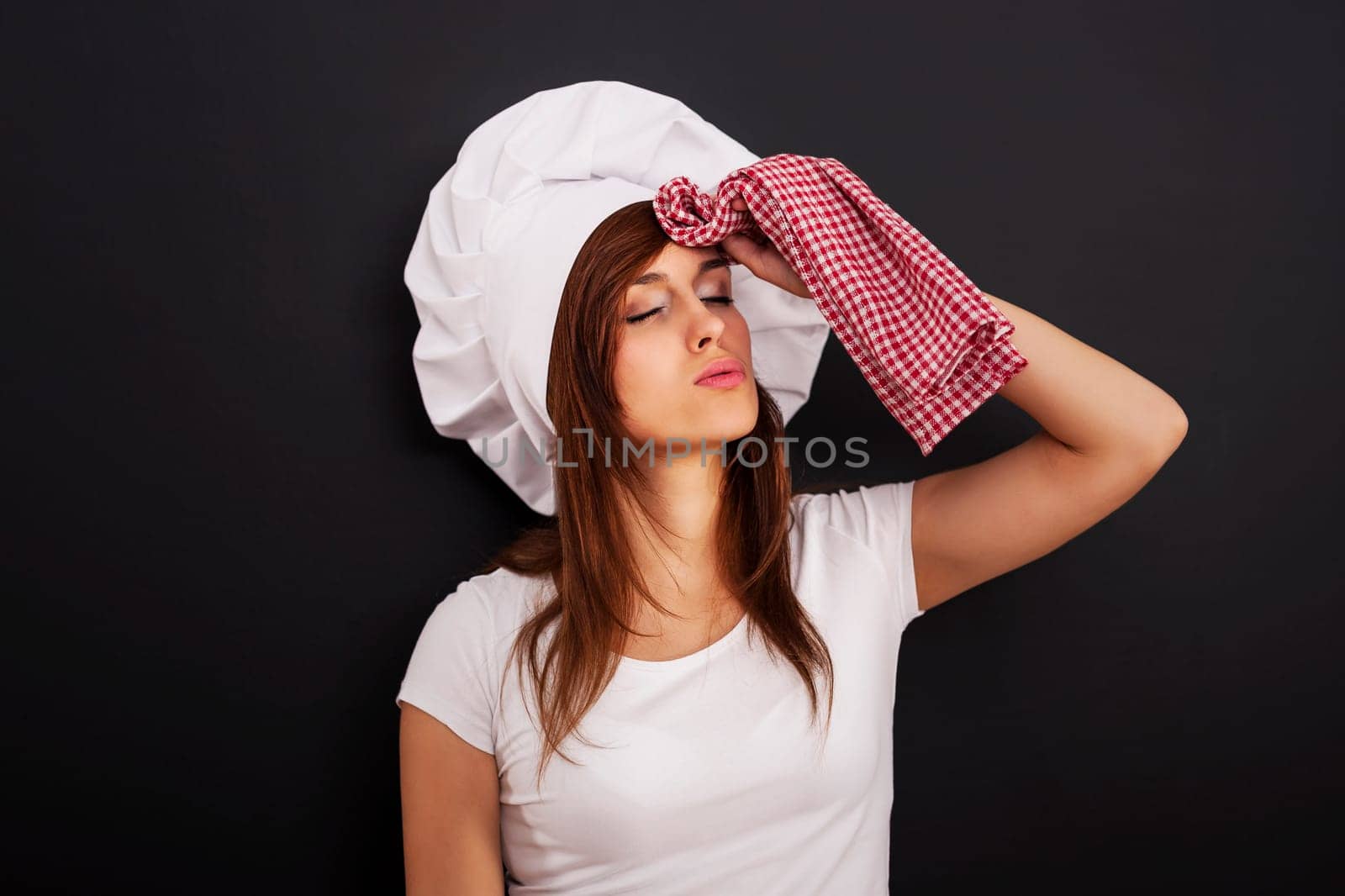Very tired female chef wiping face from sweat