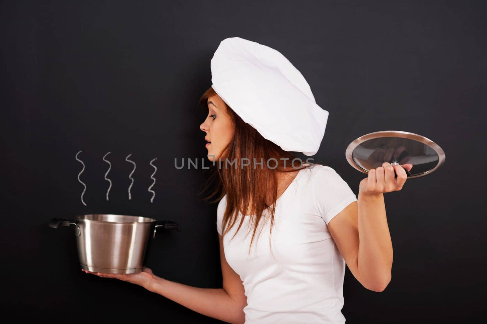 Curious female chef peeking into the pot