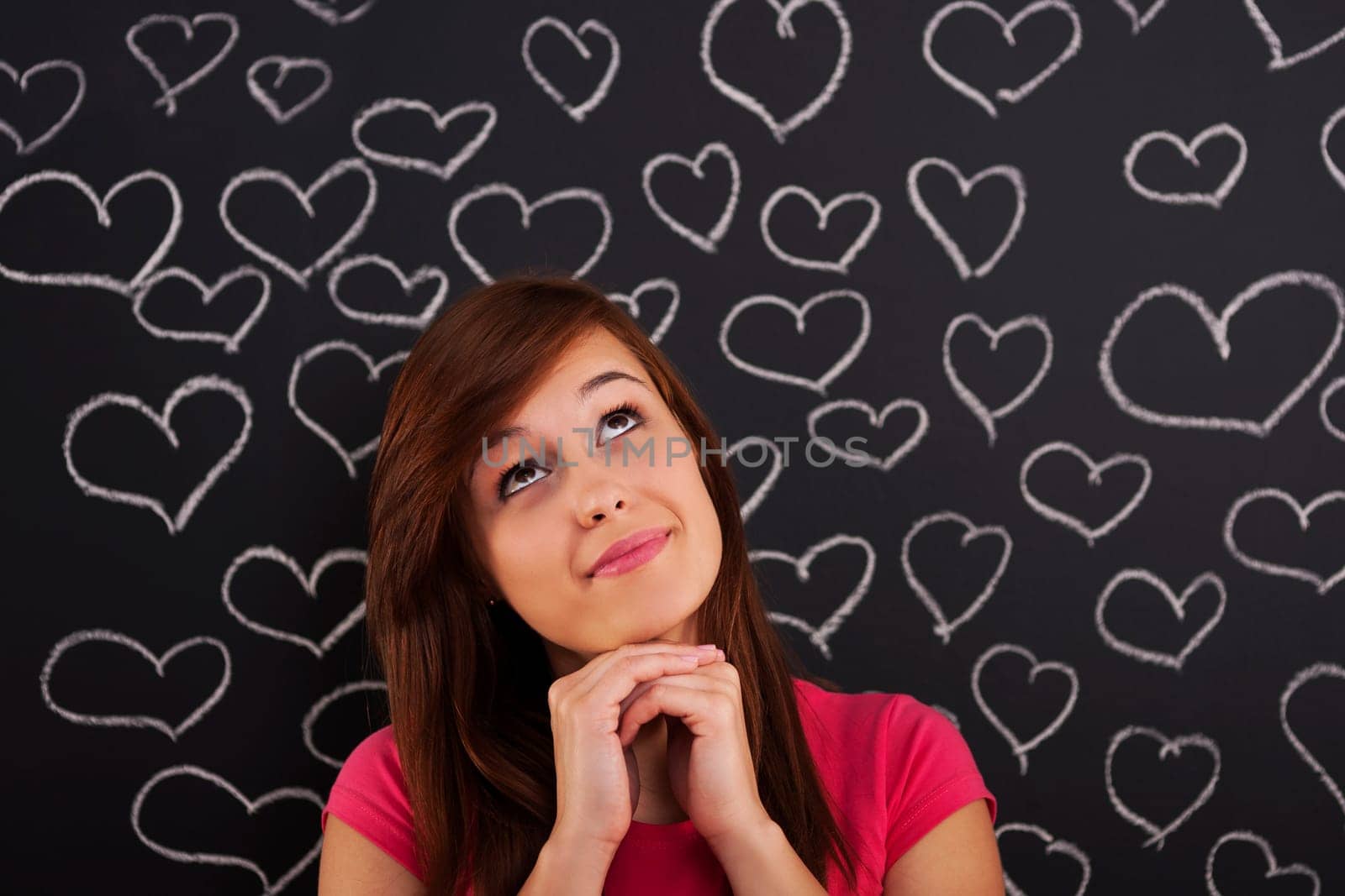 Woman looking up lovingly with hearts drawn on blackboard