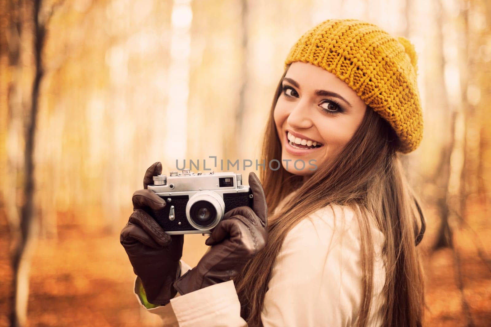 Smiling young woman holding retro camera