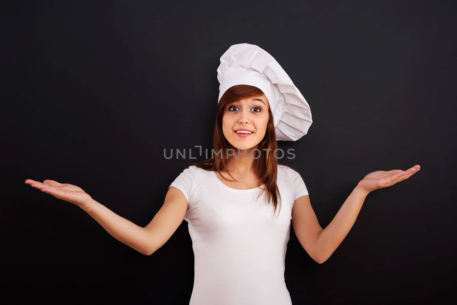 Young smiling cooking chef showing greeting sign