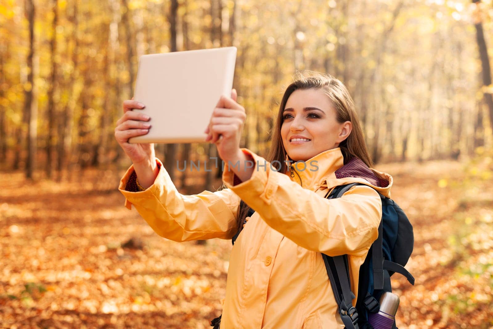 Beautiful woman taking photo by digital tablet