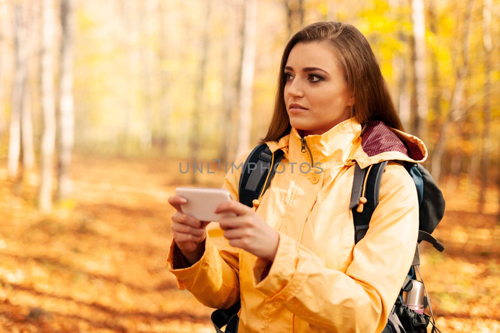 Confused young hiker with smart phone in forest