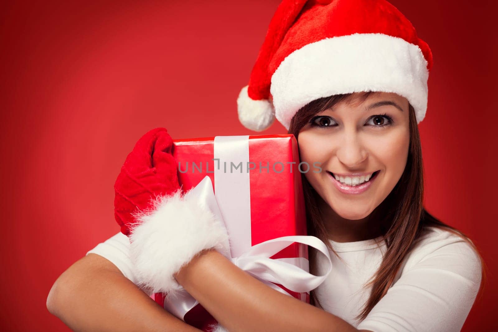 Woman holding christmas present next to her face