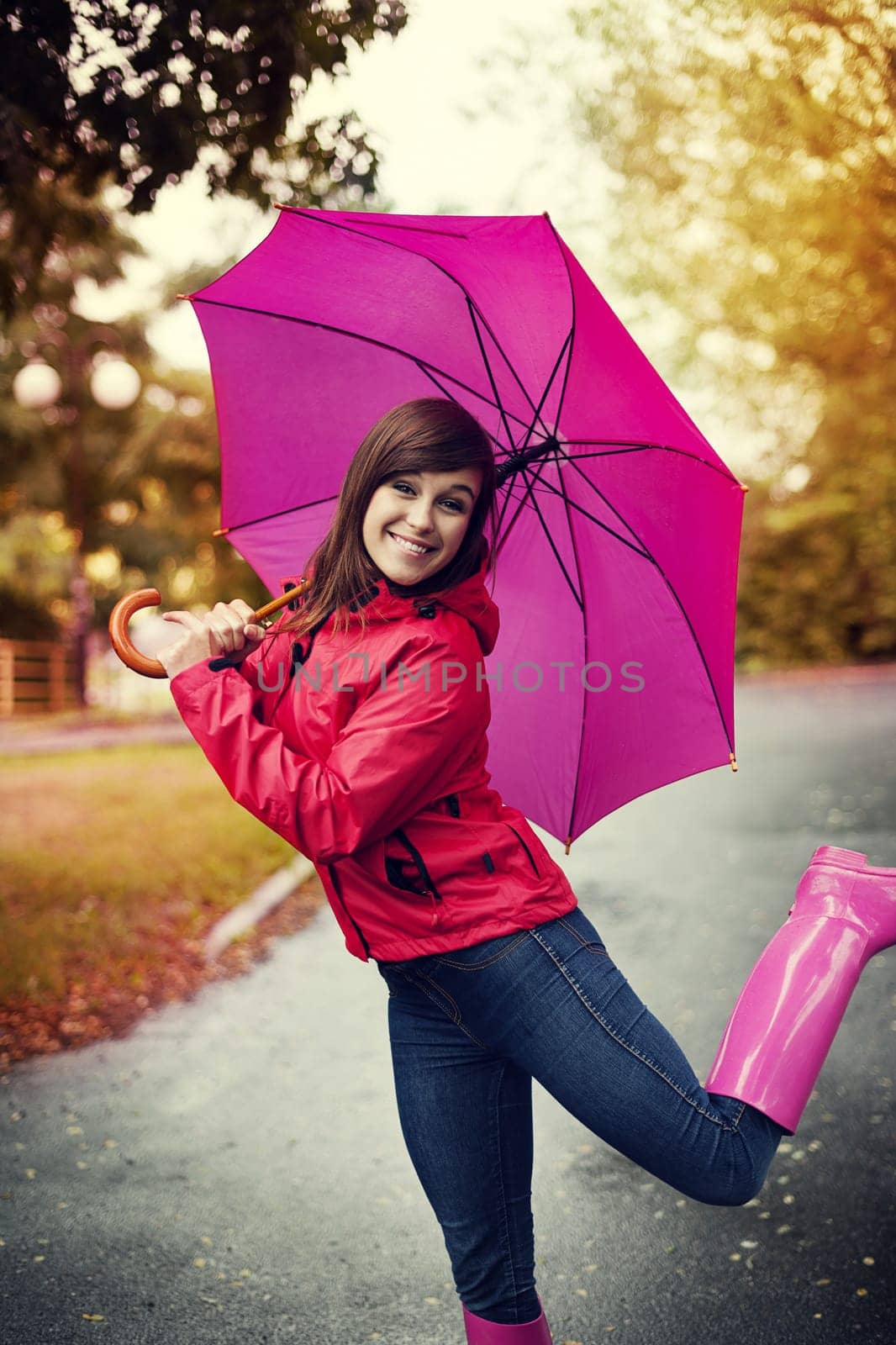 Happy woman with pink umbrella and rubber boots