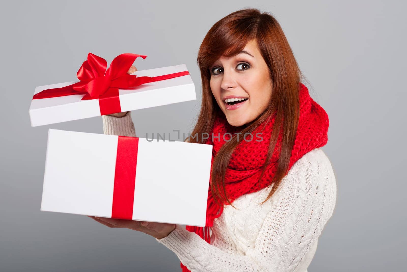 Happy young woman opening christmas gift