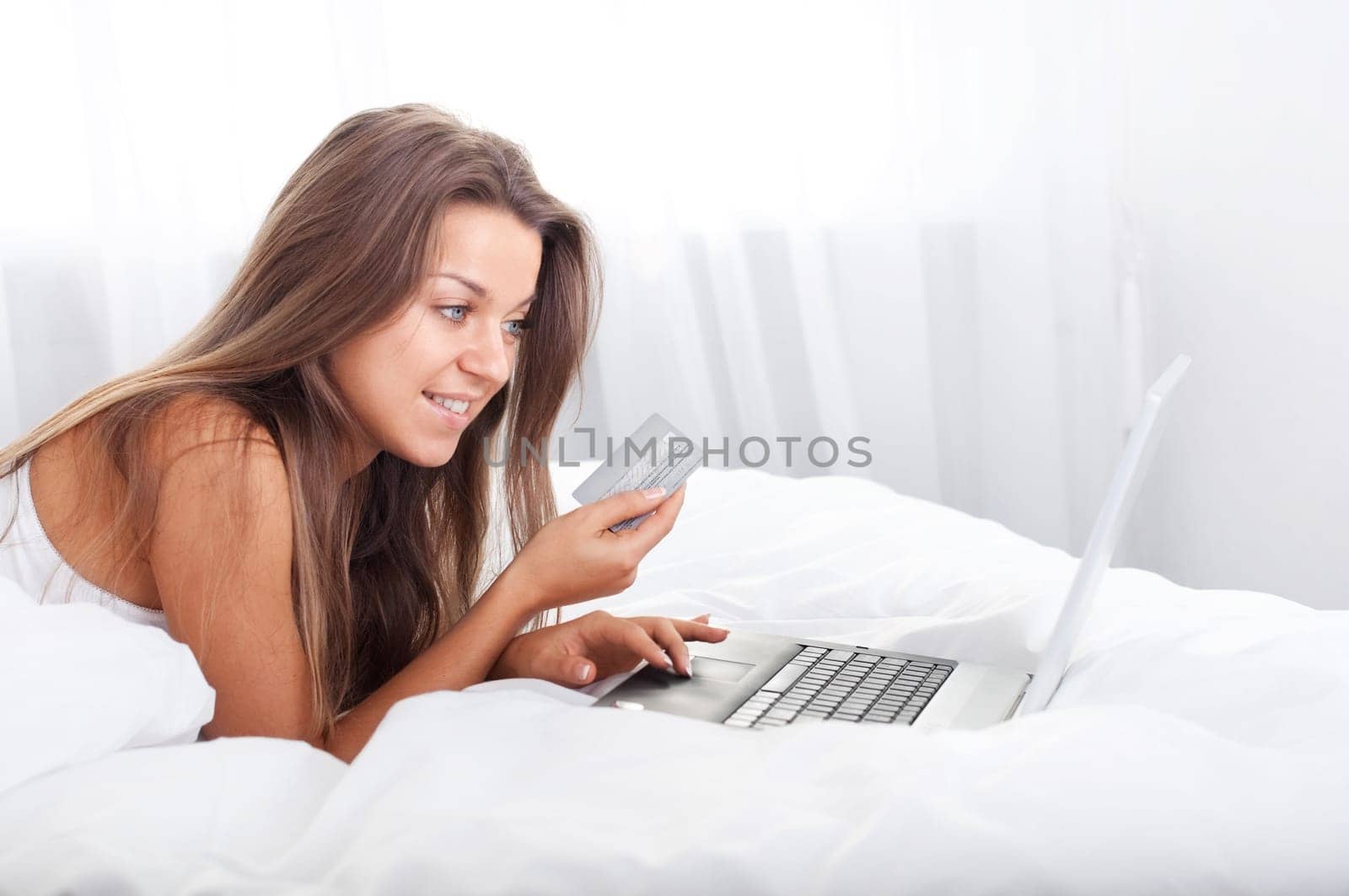 Young woman using laptop in bed