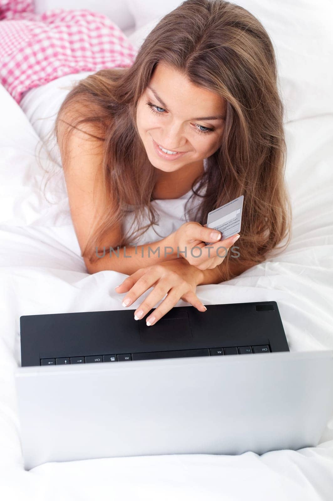 Young woman using laptop in bed