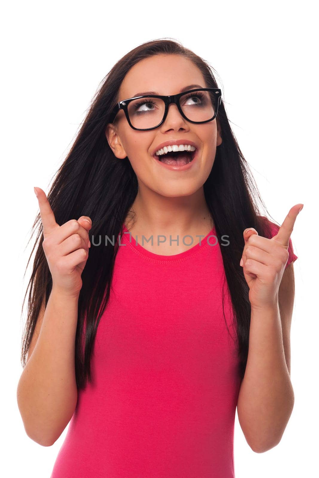 Woman wearing glasses pointing at copy space above her