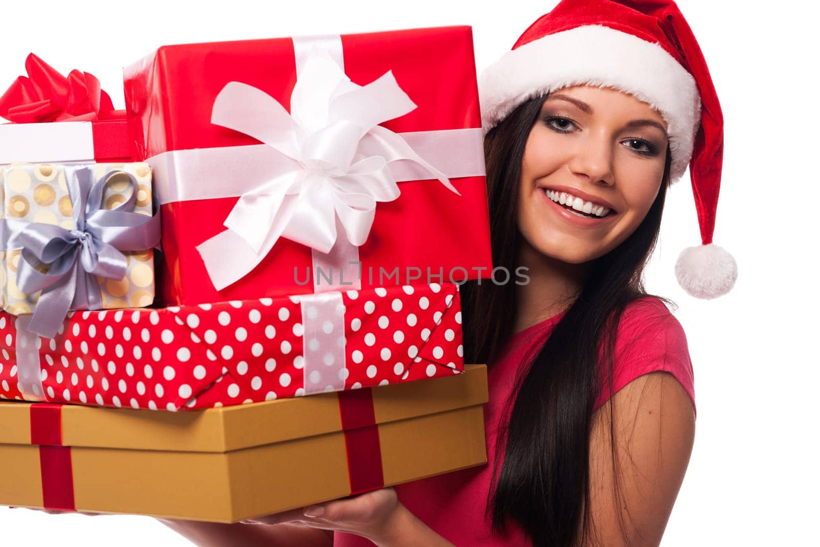 Woman wearing santa hat holding stack of christmas gifts