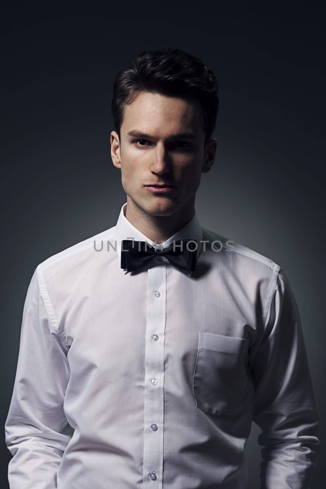 Portrait of handsome young man wearing in a shirt and bow tie