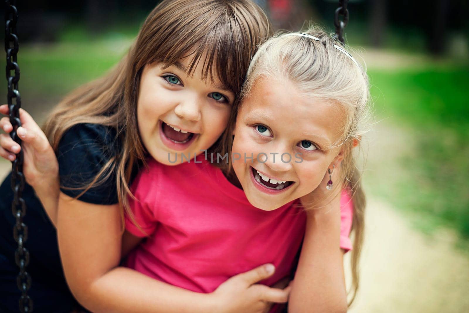 Happy little girls swinging in a park
