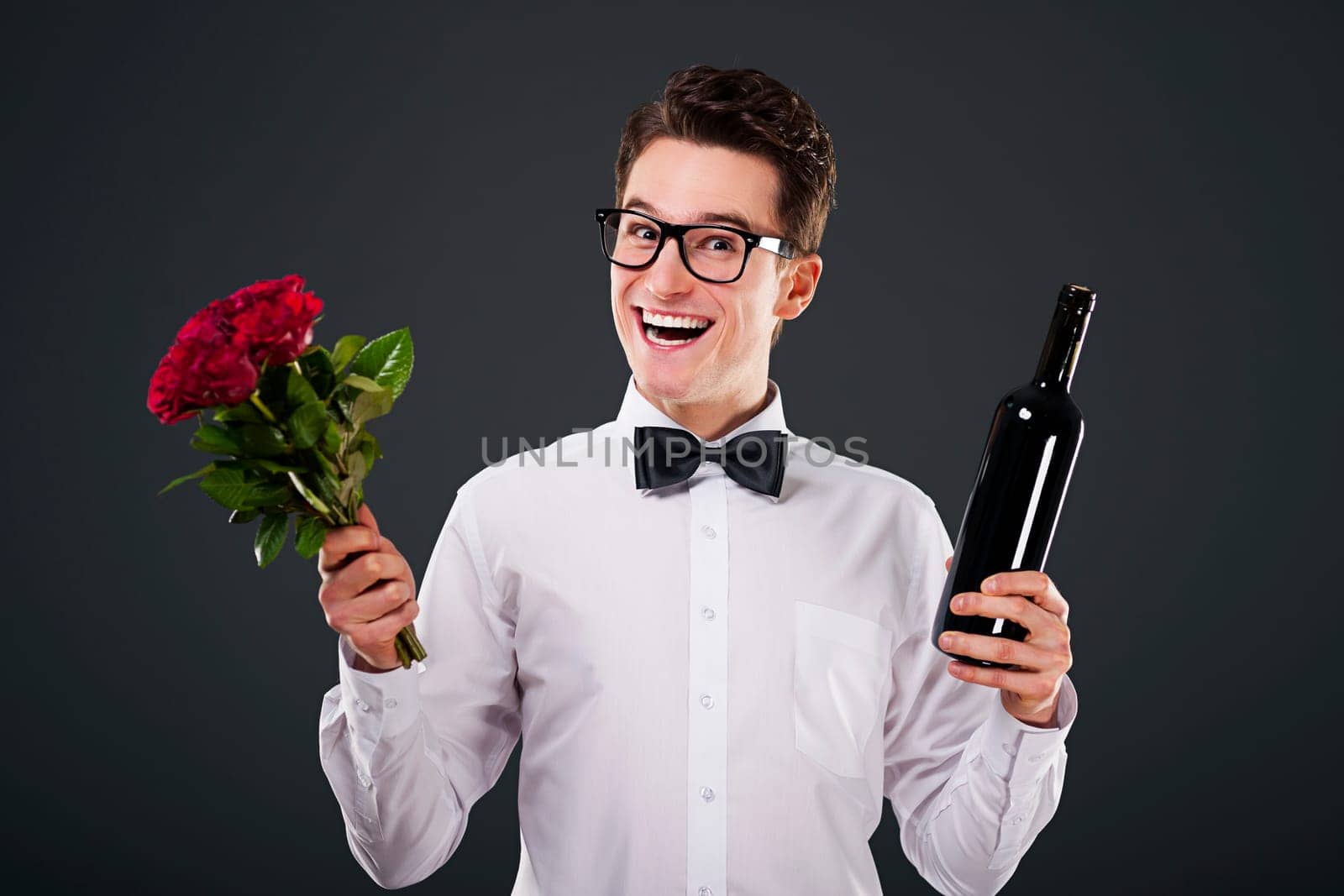 Happy man with a bouquet of roses and wine