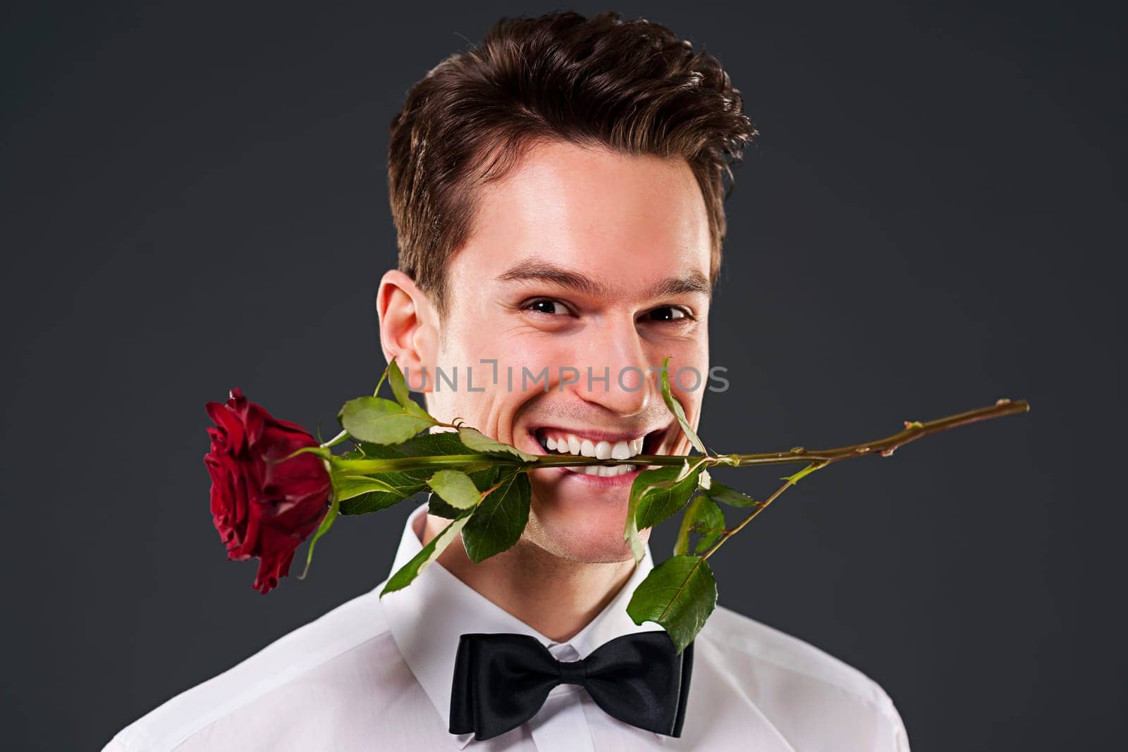 Man with a red rose in mouth