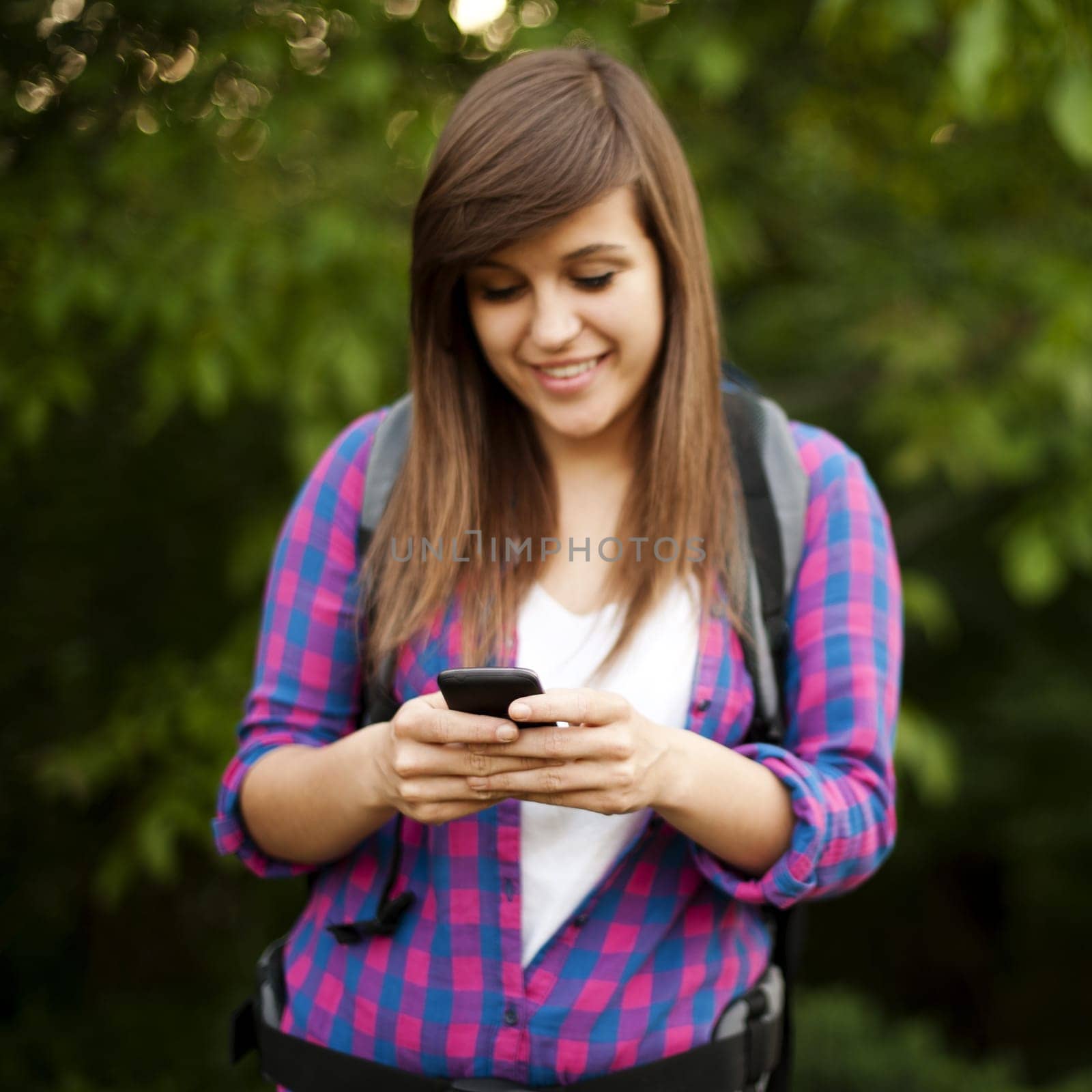 Beautiful female hiker texting