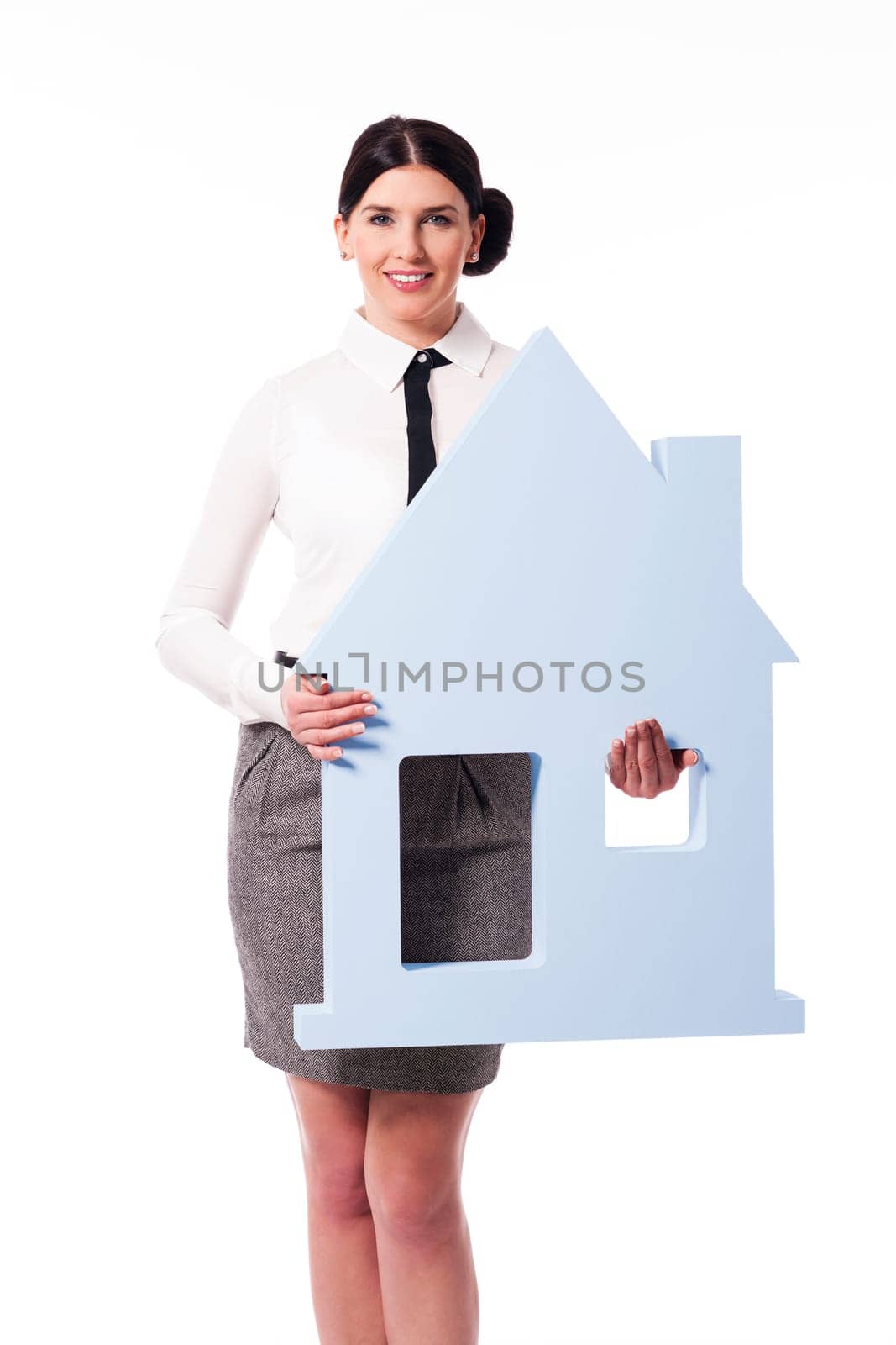 Smiling young woman holding house sign
