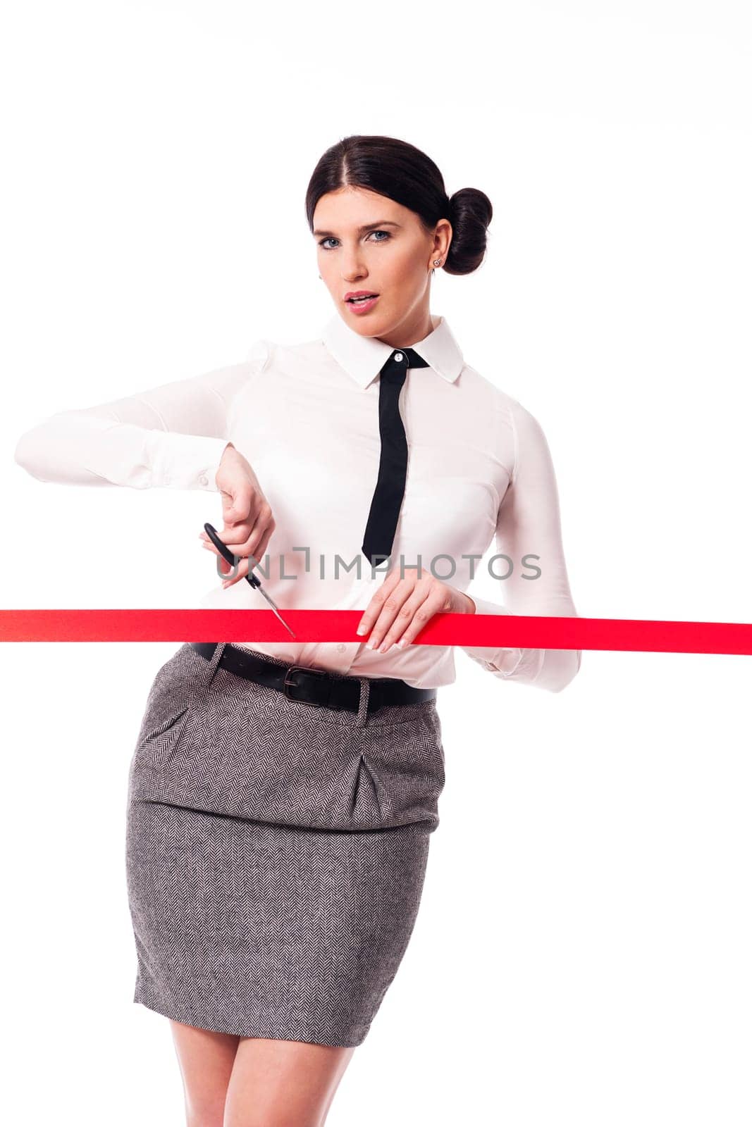 Serious and focus businesswoman cutting a red ribbon