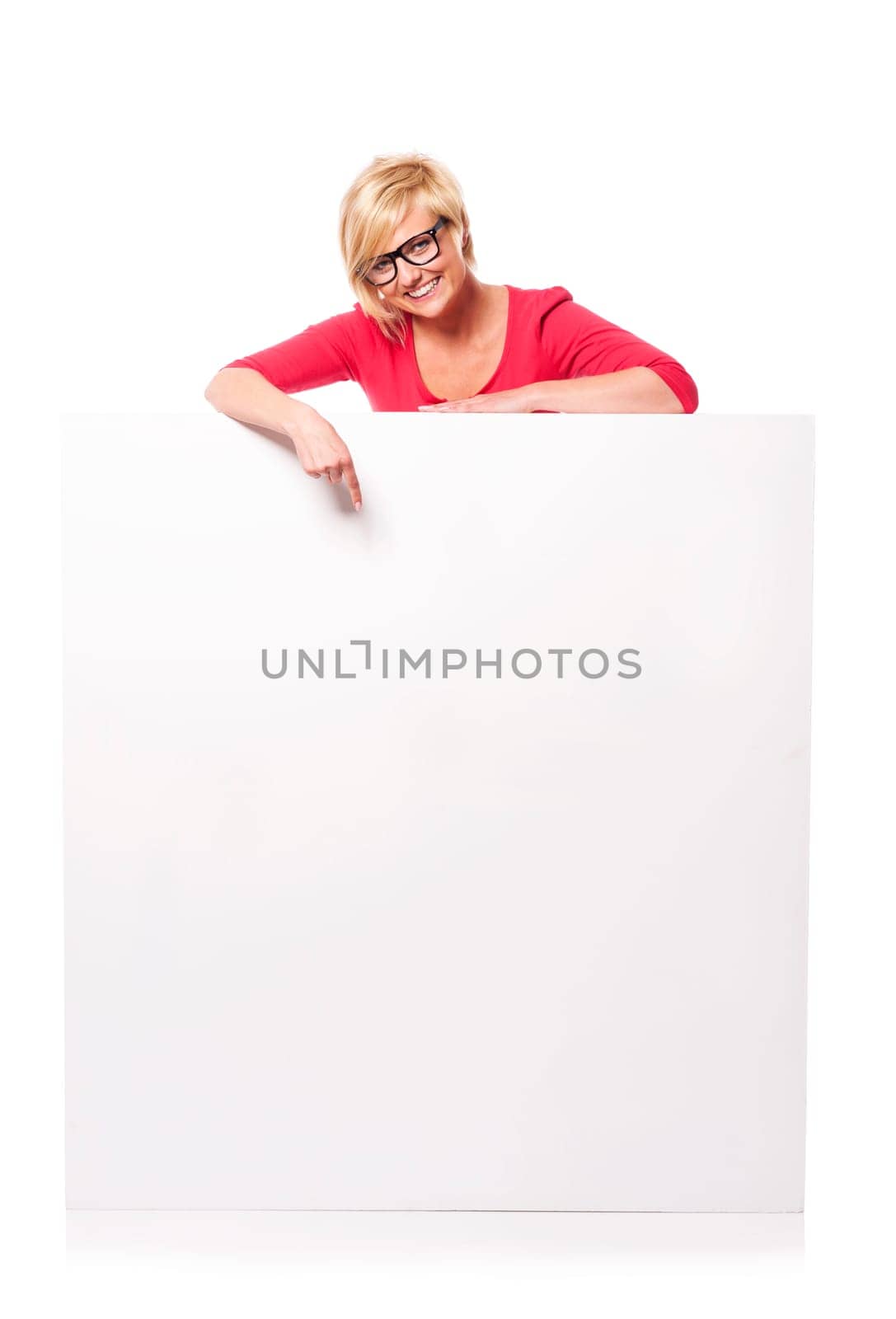 Happy young woman pointing at billboard