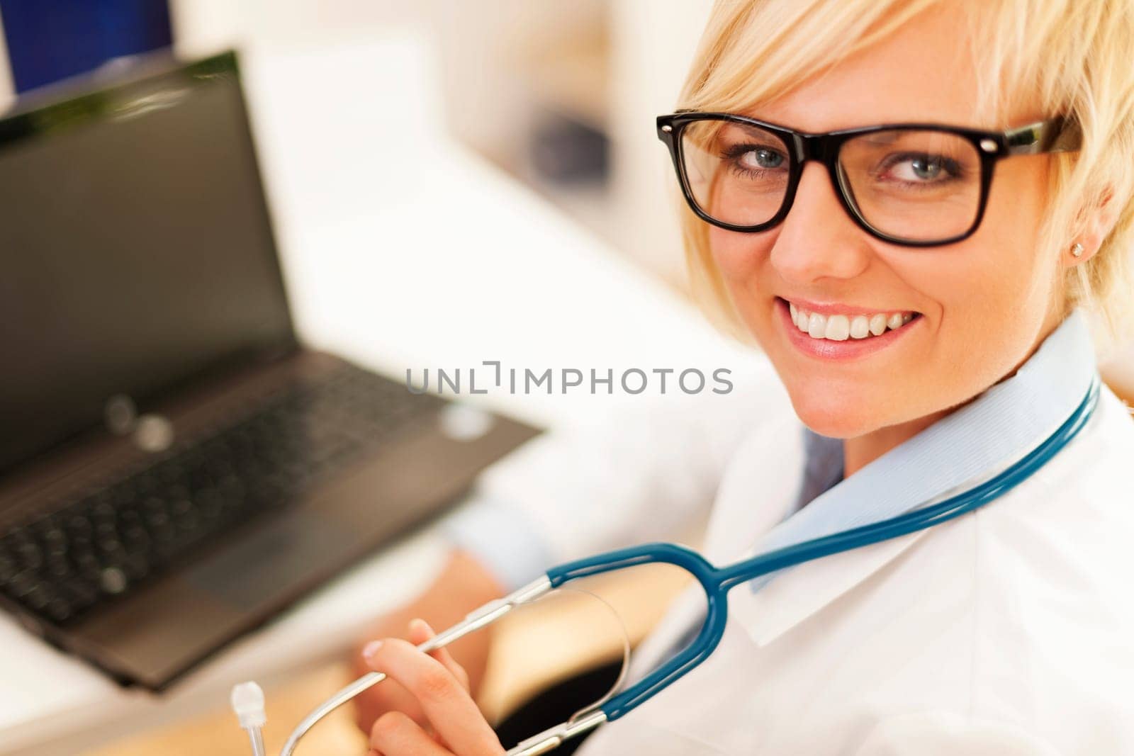 Portrait of beautiful blonde female doctor wearing glasses