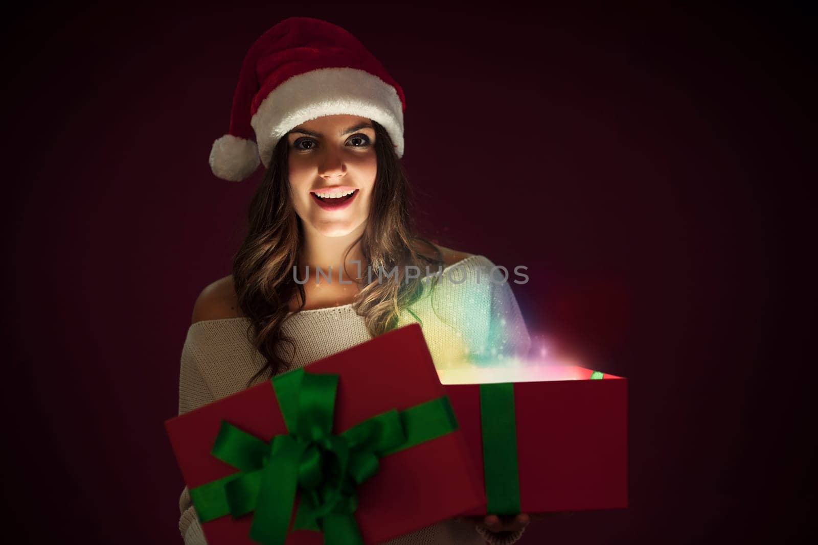 Woman with santa hat opening magic gift