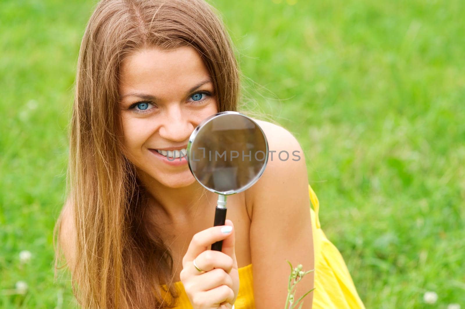 Beauty woman looking through magnifying glass