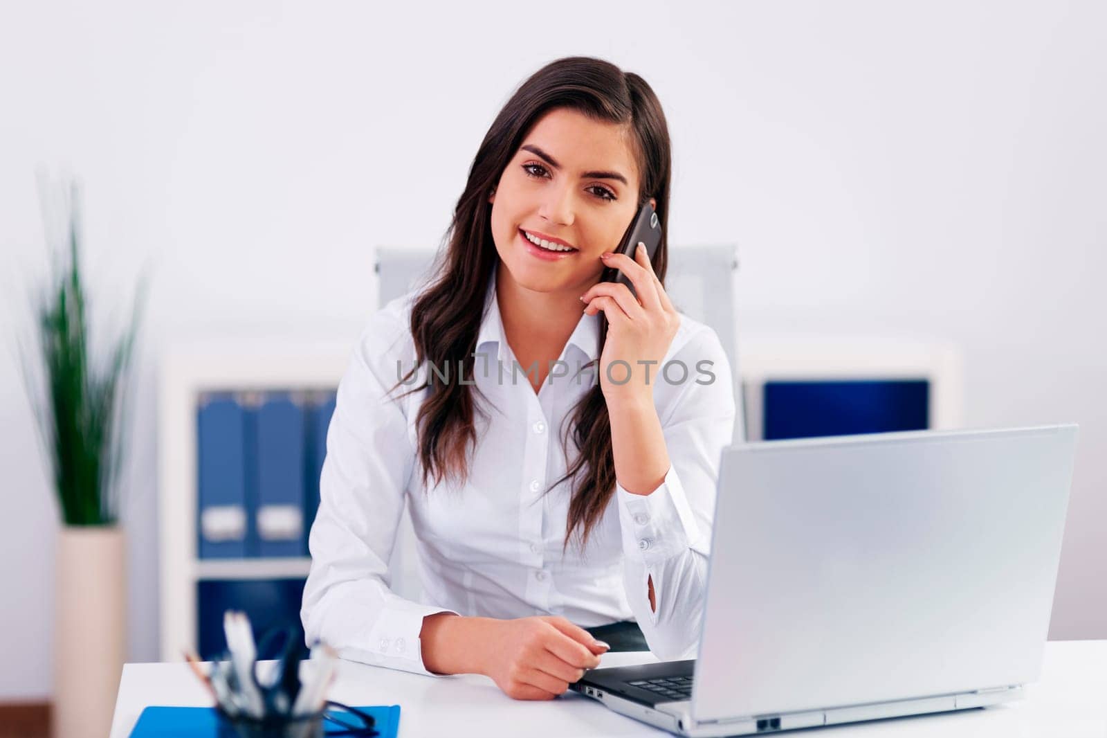 Businesswoman talking on cellphone in office