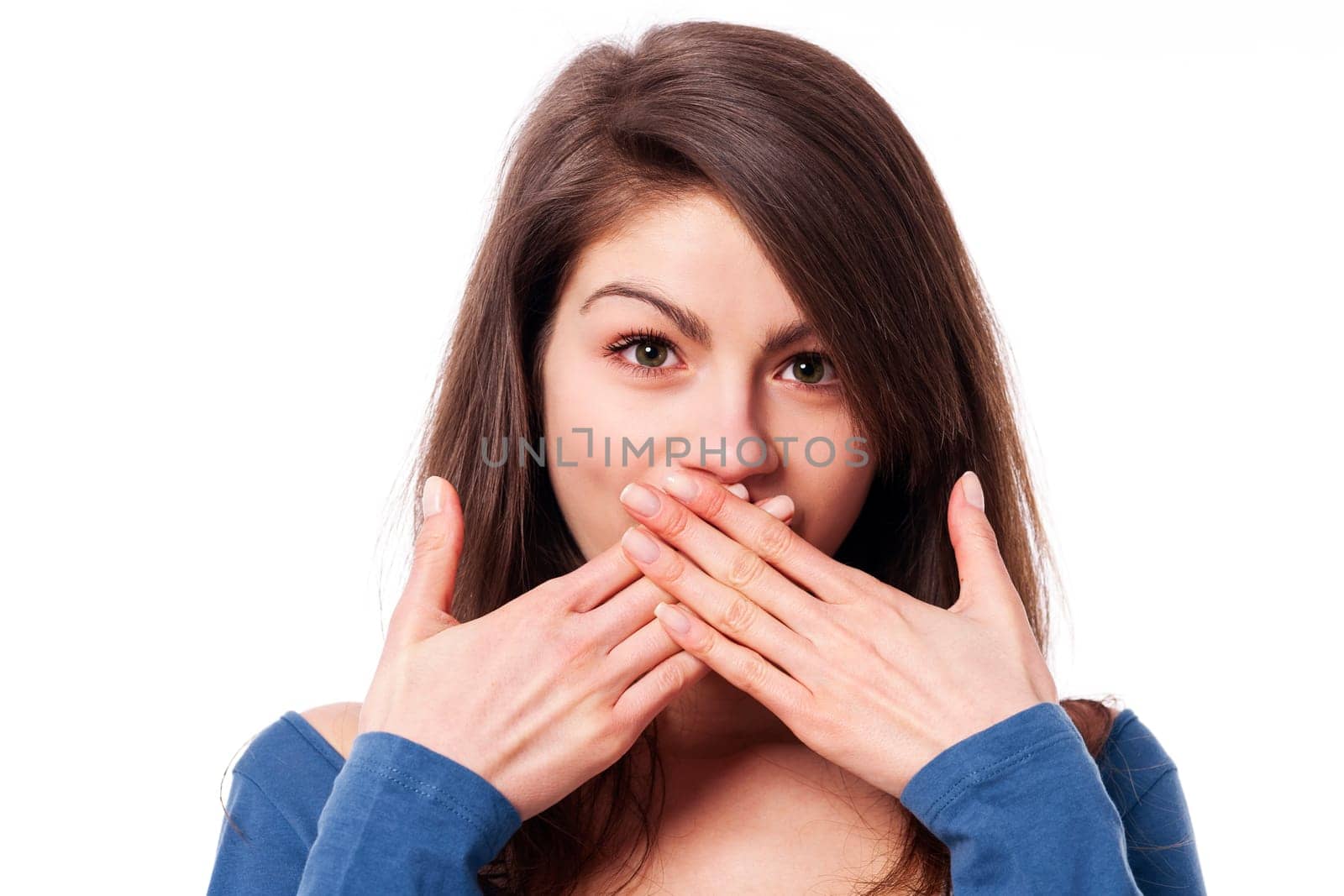 Beautiful young woman with hands covering mouth