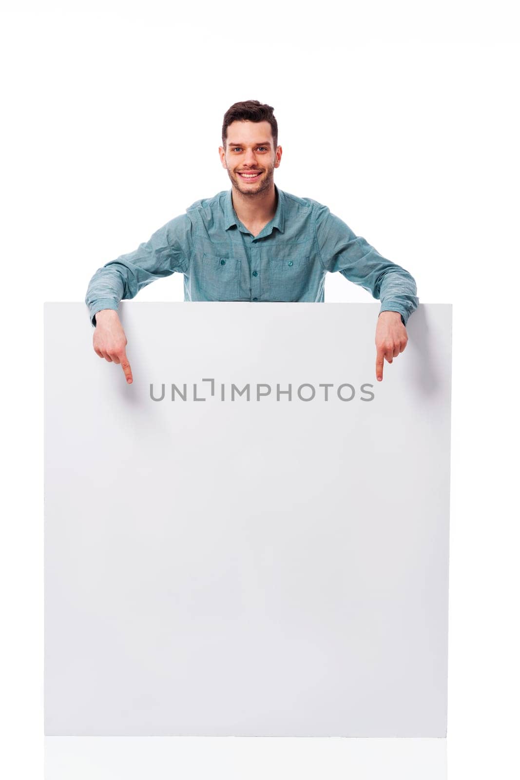 Happy young man pointing at empty board