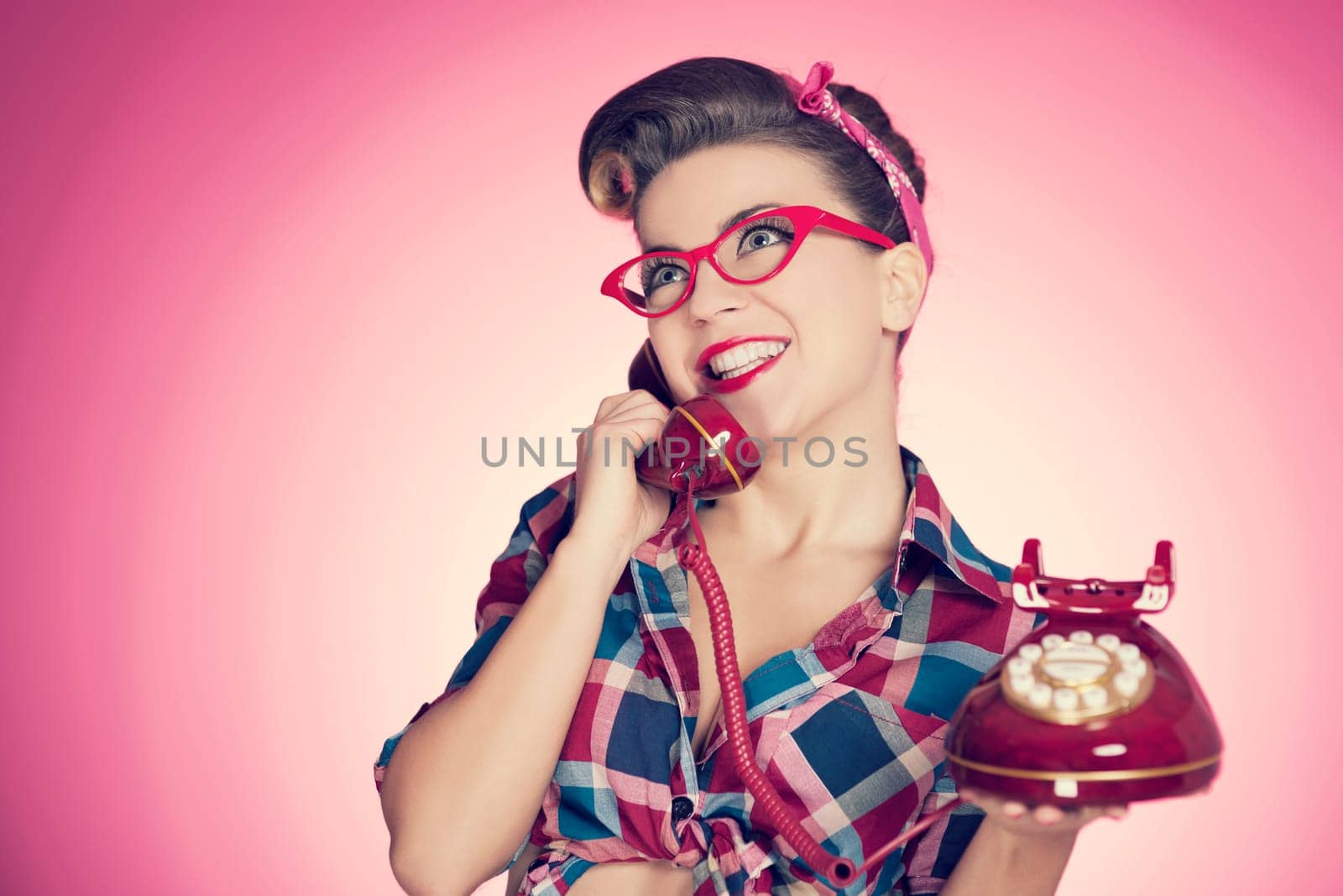 Happy pin up girl talking on retro telephone