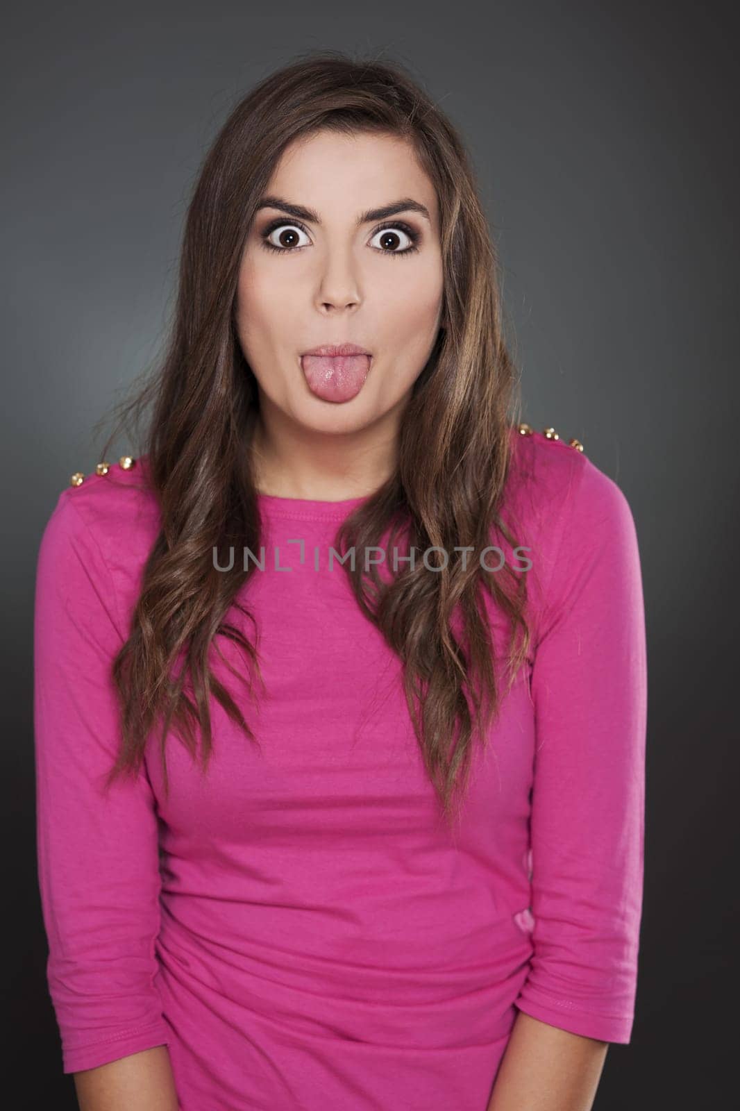 Cheerful woman shows her tongue