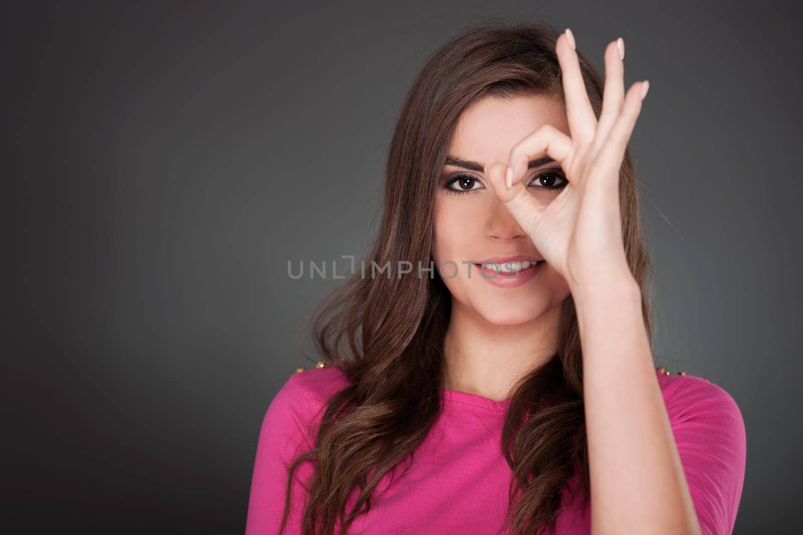 Young attractive woman showing OK