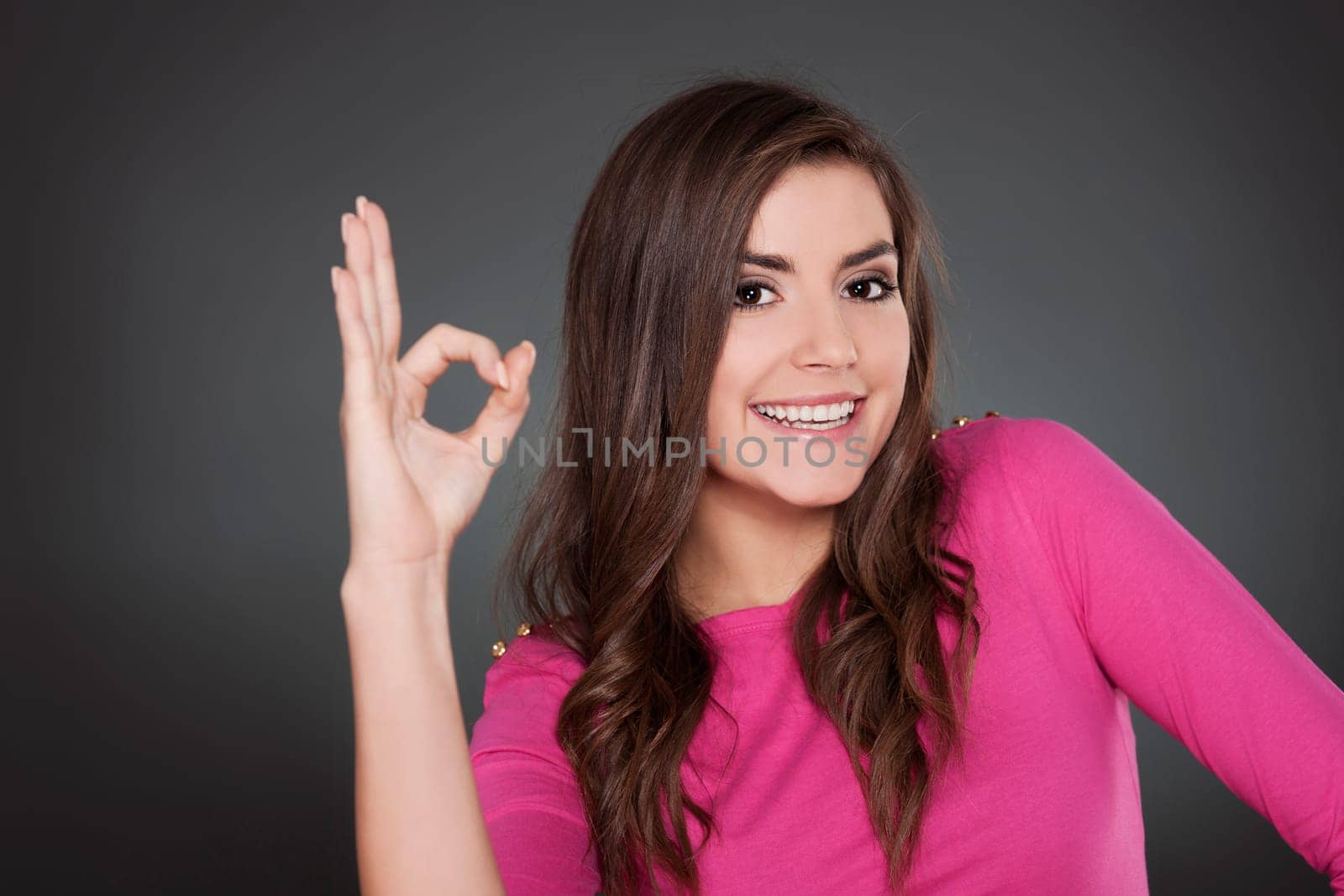 Cheeful young woman with OK sign