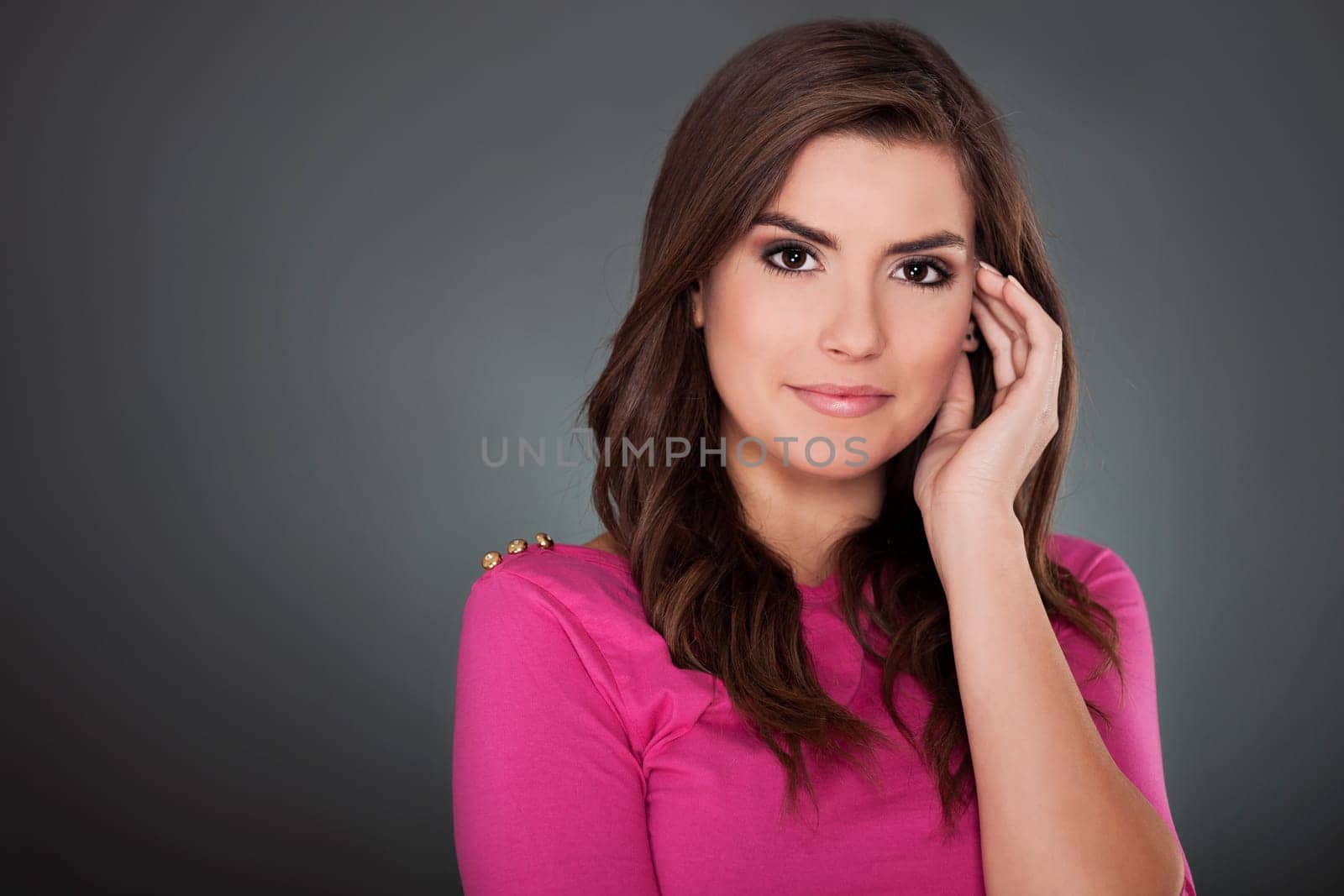 Beautiful young woman smiling on grey background