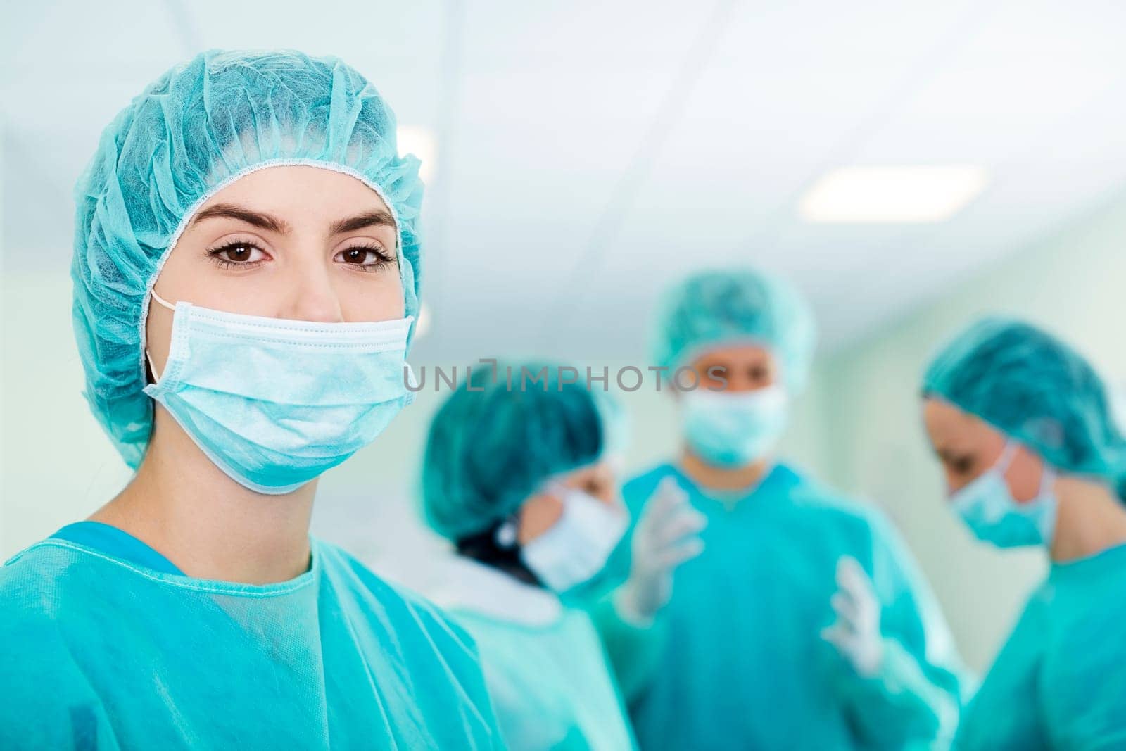 Young female surgeon with medical team in back before surgery