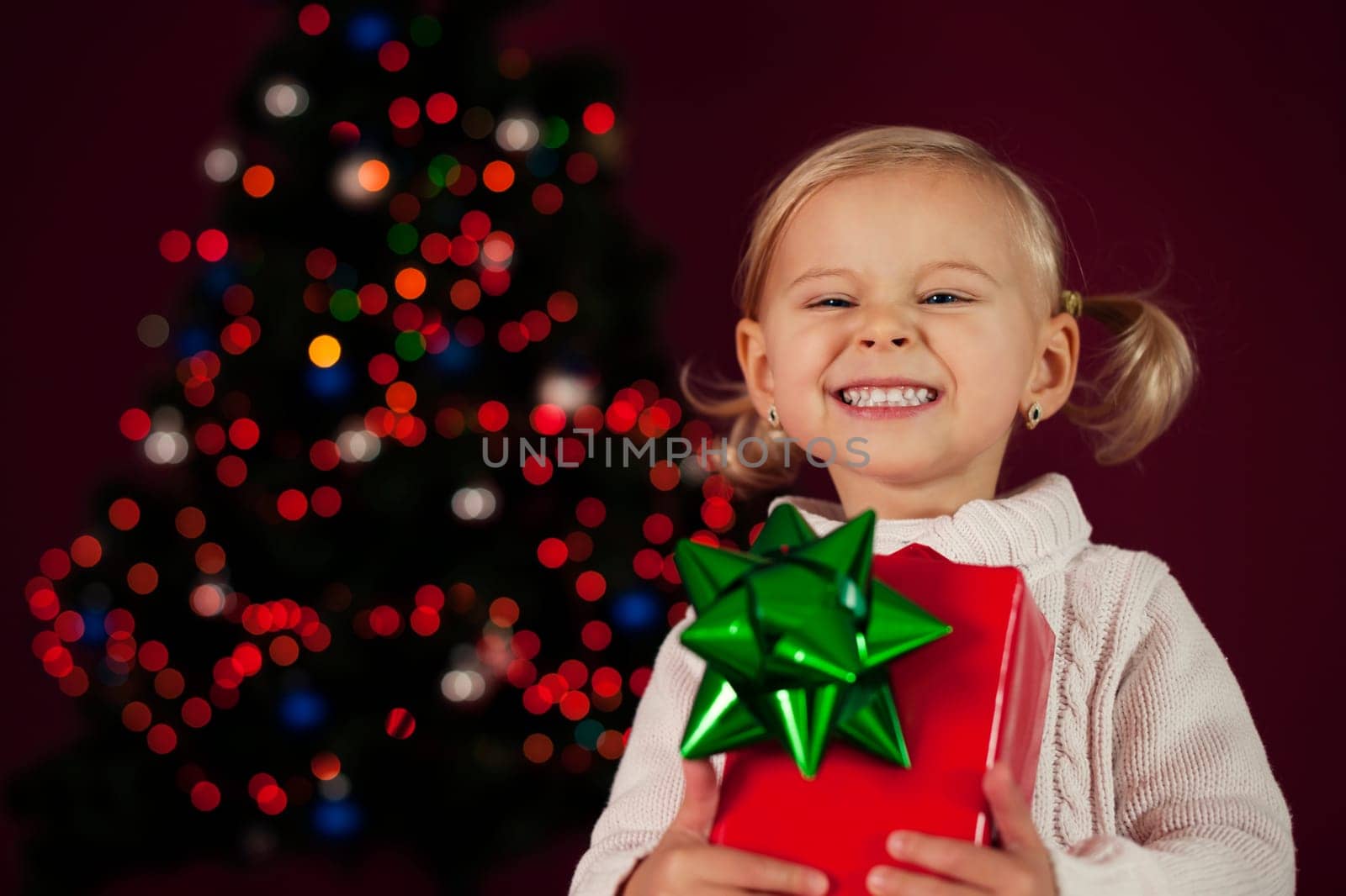 Cute little girl holding christmas gift