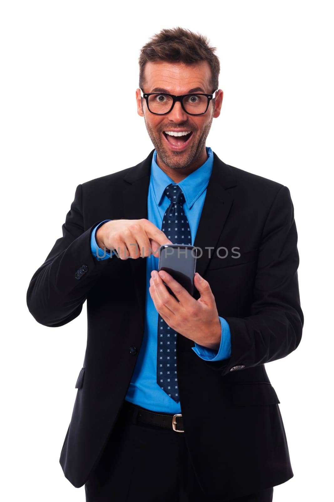 Happy and surprised businessman pointing at mobile phone