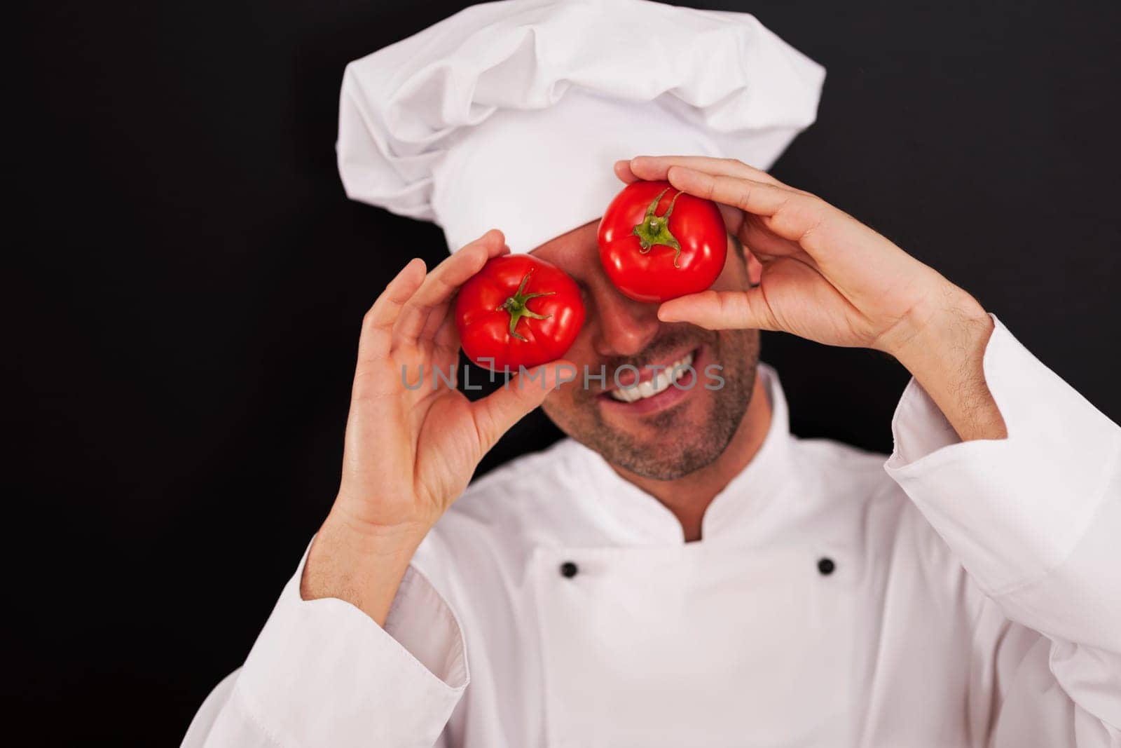 Happy chef covering his eyes of tomatoes