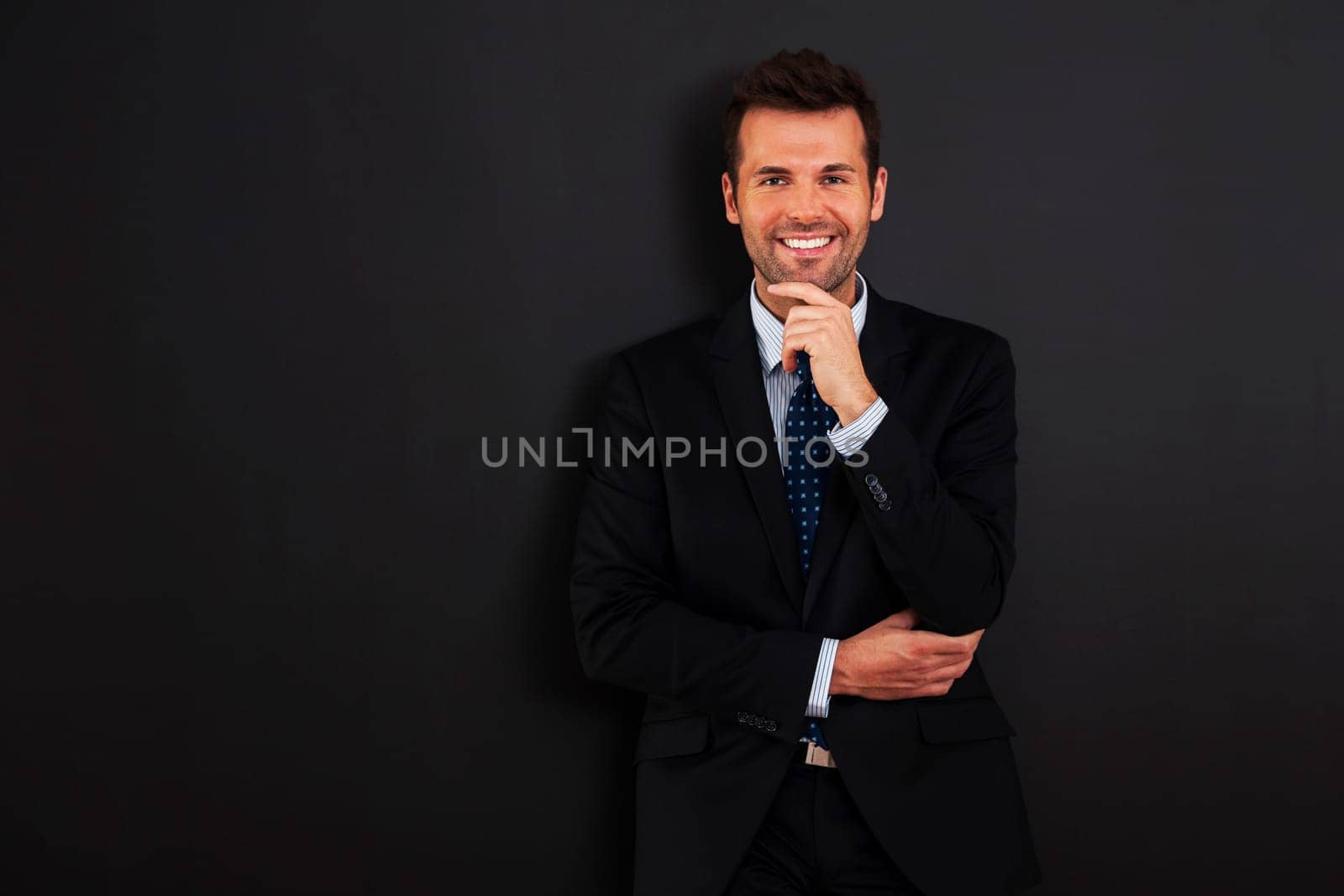 Handsome businessman standing at the blackboard