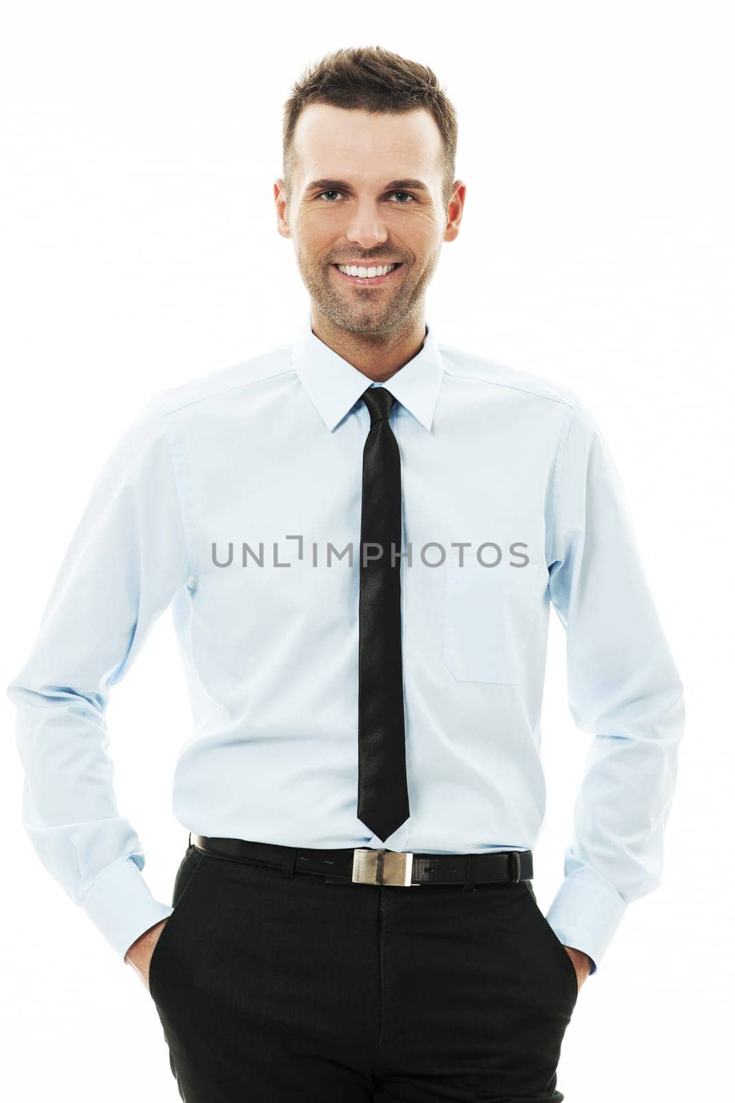 Happy businessman with his hands in pockets